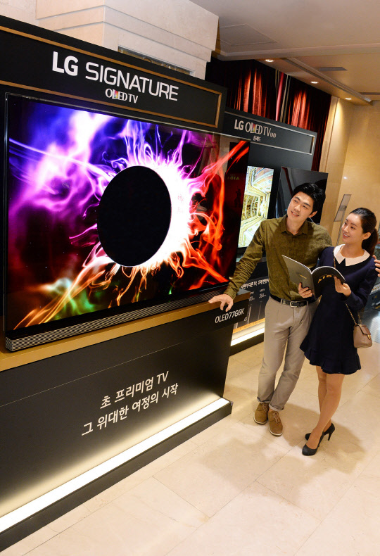 LG전자는 이달 초부터 다음달까지 서울 잠실동에 위치한 샤롯데씨어터에서 올레드 TV의 화질을 감상할 수 있는 체험존을 운영한다. 관람객들이 LG 시그니처 올레드 TV를 살펴보고 있다.<LG전자 제공>